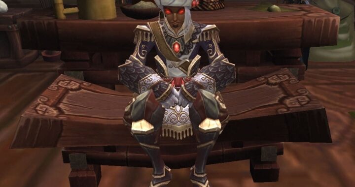 Wrathion seated at the Tavern of the Mists in Pandaria, calmly resting at a table in the inn. His imposing presence contrasts with the cozy, rustic atmosphere of the tavern